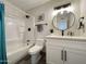 Updated bathroom with a tub, white vanity, and gray tile floors at 3748 W Rovey Ave, Phoenix, AZ 85019