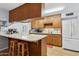 Mid-century modern kitchen with wood cabinets and a breakfast bar at 3813 W Glenn Dr, Phoenix, AZ 85051