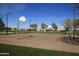 The community features a basketball court and benches surrounded by mature trees at 3883 E Santa Fe Ln, Gilbert, AZ 85297