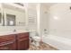 Cozy bathroom with a single sink vanity and tub with shower at 3883 E Santa Fe Ln, Gilbert, AZ 85297