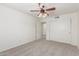 Spacious carpeted bedroom featuring a ceiling fan, neutral walls, and a sliding-door closet at 3883 E Santa Fe Ln, Gilbert, AZ 85297