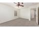 Bright bedroom features neutral carpet, ceiling fan, and a view into the hallway at 3883 E Santa Fe Ln, Gilbert, AZ 85297