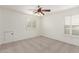 Bright bedroom with neutral carpet, ceiling fan, and white shuttered windows at 3883 E Santa Fe Ln, Gilbert, AZ 85297