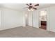 Spacious bedroom with neutral carpet and ceiling fan, adjacent to a bathroom at 3883 E Santa Fe Ln, Gilbert, AZ 85297