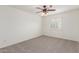 Bright bedroom with neutral carpet, ceiling fan, and white shuttered windows at 3883 E Santa Fe Ln, Gilbert, AZ 85297