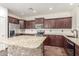 Well-lit kitchen with stainless steel appliances, granite countertops, and brown cabinets at 3883 E Santa Fe Ln, Gilbert, AZ 85297