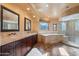 A luxurious primary bathroom featuring double sinks, tub, walk-in shower and natural light at 4245 E Claremont Ave, Paradise Valley, AZ 85253