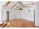 Living room featuring hardwood floors, custom shelving, a ceiling fan, and exposed wood beams at 4245 E Claremont Ave, Paradise Valley, AZ 85253