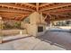 A patio kitchen area, with wooden beams, stone floor, desert landscaping and sunny skies at 4245 E Claremont Ave, Paradise Valley, AZ 85253