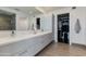 Modern bathroom featuring double vanity, a large mirror, and a glass-enclosed shower with a walk-in closet at 4422 N 75Th St # 3012, Scottsdale, AZ 85251