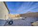 Low-maintenance backyard with desert landscaping, showcasing gravel and a view of the block fence, ideal for easy upkeep at 5267 E Diatomite Dr, San Tan Valley, AZ 85143