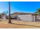 View of home's side, showcasing the unique brickwork and landscaping at 530 N Miller St, Mesa, AZ 85203