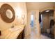 Well-appointed bathroom with a decorative mirror, vanity, and access to a tiled shower at 537 W Encanto Blvd, Phoenix, AZ 85003