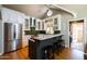 Open concept kitchen with white cabinets, green backsplash, stainless steel appliances, and breakfast bar at 537 W Encanto Blvd, Phoenix, AZ 85003