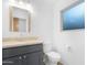 Bathroom featuring a blue-grey vanity with a stone countertop and a frosted window for privacy at 5421 W Brown St, Glendale, AZ 85302