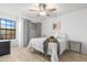 Bright bedroom with wood-look floors, ceiling fan, and a comfy bed with stylish gray bedding at 5421 W Brown St, Glendale, AZ 85302