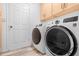 Laundry room featuring white cabinets above modern washer and dryer units at 5421 W Brown St, Glendale, AZ 85302