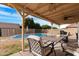 Covered patio with outdoor seating and barbecue with pool in the background at 5421 W Brown St, Glendale, AZ 85302