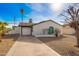 Cute ranch home with a teal door, two-car garage, and a gravel driveway at 6201 W Maryland Ave, Glendale, AZ 85301