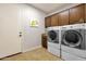 Bright laundry room with washer, dryer, and wood cabinets at 7635 W Rock Springs Dr, Peoria, AZ 85383