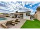 Expansive backyard featuring a pool, patio with lounge furniture, artificial turf, and a well-maintained exterior at 8024 E Hubbell St, Scottsdale, AZ 85257