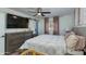 Cozy bedroom with ceiling fan, large TV, sliding barn door, soft bedding, and natural light from the window at 8024 E Hubbell St, Scottsdale, AZ 85257