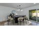 Bright dining room features modern chandelier, oval table with seating for six, and sliding glass doors to outside patio at 8024 E Hubbell St, Scottsdale, AZ 85257