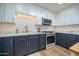 Modern kitchen with white and blue cabinets and marble countertops at 8413 E Sheridan St, Scottsdale, AZ 85257