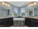 Bright bathroom featuring a soaking tub with views and double sink vanities at 852 E Gary Ln, Phoenix, AZ 85042