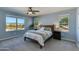 Light and airy main bedroom with carpet, ceiling fan, and three windows overlooking the desert landscape at 852 E Gary Ln, Phoenix, AZ 85042