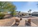 Charming backyard featuring a brick patio with rocking chairs, decorative fencing, and mature landscaping at 9618 W Appaloosa Dr, Sun City, AZ 85373