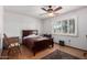 Bright bedroom featuring a large window with shutters, wood flooring, and neutral walls at 9618 W Appaloosa Dr, Sun City, AZ 85373