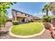 Landscaped backyard with a large grassy area and covered patio at 11050 E Ravenna Ave, Mesa, AZ 85212