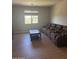Spacious living room with a wall-size couch and a window at 11050 E Ravenna Ave, Mesa, AZ 85212