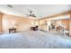 Open living room with a ceiling fan, fireplace, and access to a patio at 11050 E Ravenna Ave, Mesa, AZ 85212