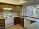 Functional kitchen with wood cabinets, white appliances, and natural light at 1550 N Stapley Dr # 35, Mesa, AZ 85203