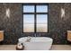 Bright bathroom featuring luxurious freestanding soaking tub with tile accent wall and natural light at 15609 E Palatial Estates Dr, Fountain Hills, AZ 85268