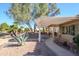 Relaxing backyard patio with pergola, stone pathway, and desert landscaping at 15666 W Arbor Trl, Surprise, AZ 85374