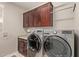 Convenient laundry room with washer, dryer, and upper cabinets at 16365 W Indianola Ave, Goodyear, AZ 85395