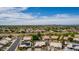 Expansive aerial view showcasing a community with well-maintained homes and mature landscaping under a blue sky at 18014 N 63Rd Ln, Glendale, AZ 85308