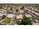 A beautiful aerial shot highlights a residential neighborhood with mature landscaping, pools, and tile roofs at 18014 N 63Rd Ln, Glendale, AZ 85308