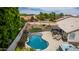 Backyard featuring a sparkling pool, hot tub, covered patio, and a well-maintained artificial turf area at 18014 N 63Rd Ln, Glendale, AZ 85308