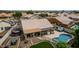 Aerial view of the backyard with a pool, hot tub, covered patio, fire pit, and artificial turf at 18014 N 63Rd Ln, Glendale, AZ 85308