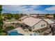 Backyard showcasing a pool, hot tub, covered patio, fire pit, and lush green artificial turf at 18014 N 63Rd Ln, Glendale, AZ 85308