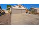 Single-story home boasting a desert landscape, a two-car garage, and an American flag at 18014 N 63Rd Ln, Glendale, AZ 85308