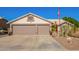 Single-story home showcasing a desert landscape, a two-car garage, and an American flag at 18014 N 63Rd Ln, Glendale, AZ 85308