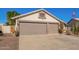 Single-story home featuring a desert landscape, a two-car garage, and an American flag at 18014 N 63Rd Ln, Glendale, AZ 85308
