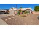 Single-story home showcasing a desert landscape, a two-car garage, and an American flag at 18014 N 63Rd Ln, Glendale, AZ 85308