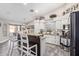 Open kitchen features modern appliances, white cabinets, granite countertops, and a breakfast bar with seating at 18014 N 63Rd Ln, Glendale, AZ 85308
