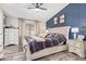 This primary bedroom features a blue accent wall, a tufted headboard, and designer dressers at 18014 N 63Rd Ln, Glendale, AZ 85308